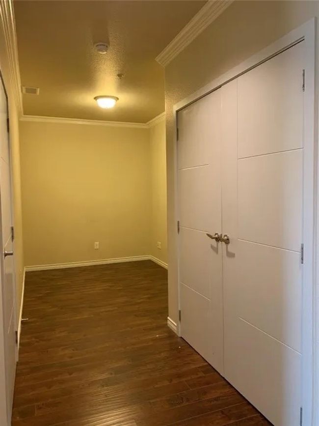 Unfurnished bedroom with ornamental molding, wood finished floors, and a closet | Image 26