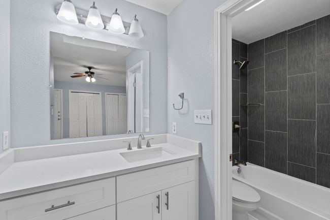 Bathroom with vanity, shower / tub combination, and a ceiling fan | Image 25