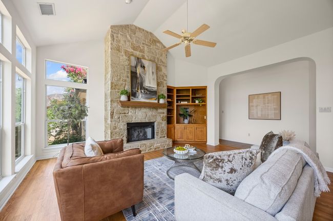 Spacious and filled with natural light, the living room showcases north-facing windows on one side and a beautiful stone fireplace. The generous layout offers flexibility for a variety of furniture arrangements to suit your style. | Image 7