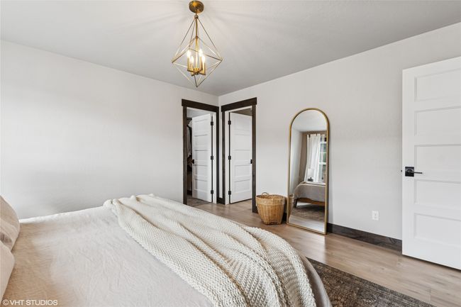 Bedroom featuring baseboards, an inviting chandelier, and wood finished floors | Image 24