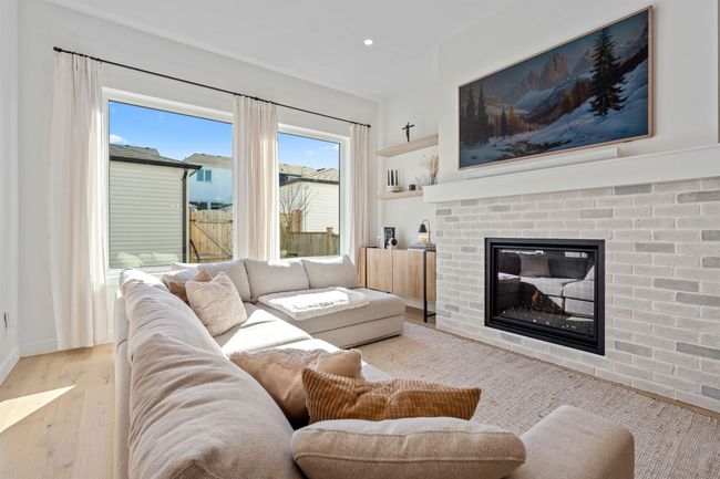 Living area featuring hardwood / wood-style flooring, a brick fireplace, and recessed lighting | Image 7