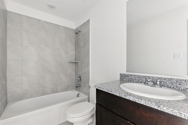 Full bathroom featuring bathing tub / shower combination, vanity, and toilet | Image 11