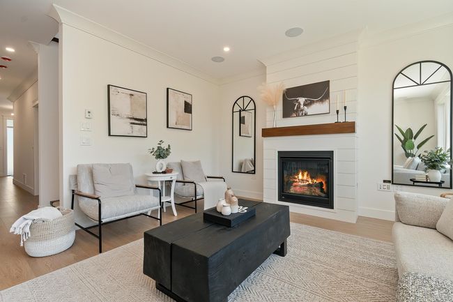Living room with crown molding, wood finished floors, a large fireplace, and recessed lighting | Image 12