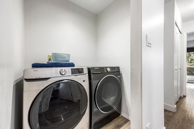 Laundry area featuring washer and clothes dryer, laundry area, baseboards, and wood finished floors | Image 23