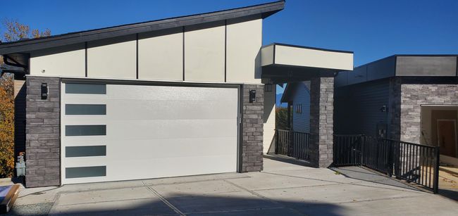 Exterior space featuring board and batten siding, driveway, and stone siding | Image 29