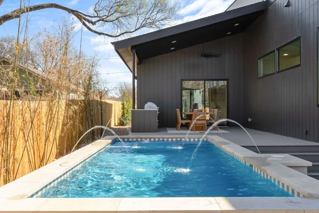 View of swimming pool featuring a fenced in pool, a patio, a ceiling fan, and fence | Image 31