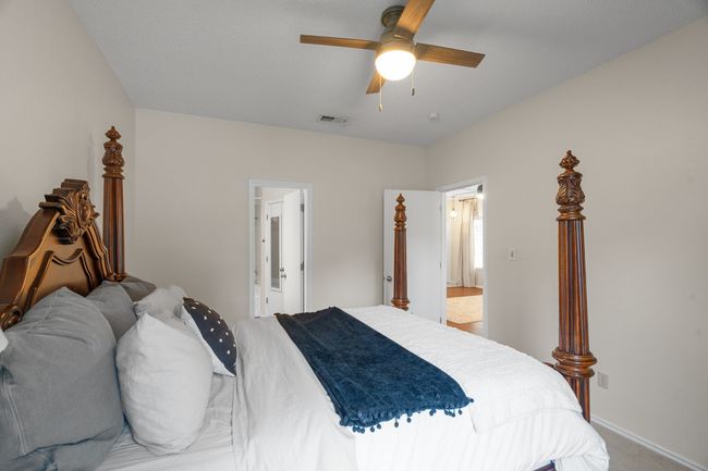 Carpeted bedroom with a ceiling fan and ensuite bathroom | Image 14