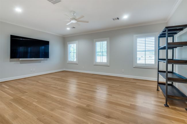 Unfurnished living room featuring visible vents, crown molding, light wood-style flooring, and a ceiling fan | Image 22