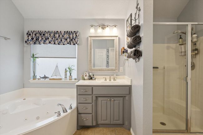 Primary bathroom featuring a separate shower, a tub with jets, vanity, and tile patterned flooring | Image 22