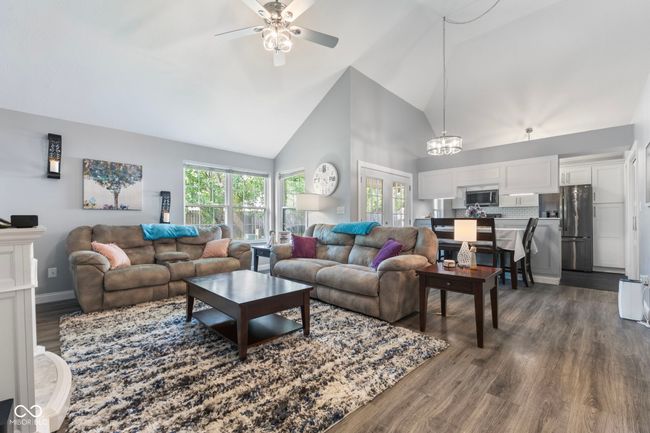 living area featuring high vaulted ceiling, dark wood finished floors, a ceiling fan, and healthy amount of natural light | Image 6