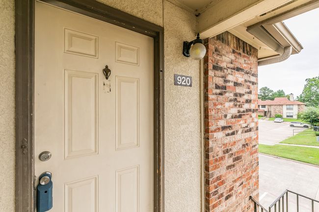 Entrance to property featuring stucco siding, brick siding, and a porch | Image 34