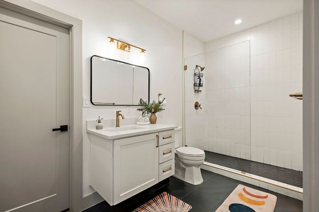 Full bath with tile patterned floors, tiled shower, vanity, toilet, and recessed lighting | Image 15