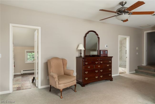 Living area featuring carpet flooring, ceiling fan, and a baseboard heating unit | Image 39