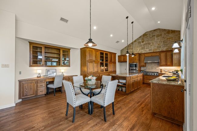 The breakfast area serves as a central hub, seamlessly connecting the living room and kitchen. A built-in desk with custom cabinetry adds a practical touch. | Image 10