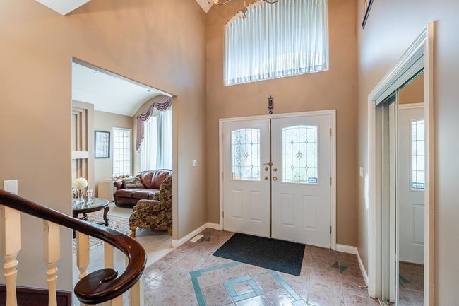 Foyer with baseboards, a high ceiling, and light tile patterned floors | Image 8