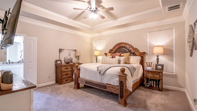 Primary Bedroom with light carpet, a tray ceiling, crown molding | Image 12