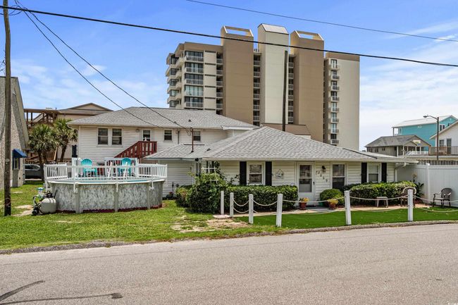 View of front facade with a front yard, an outdoor pool, and a shingled roof | Image 28