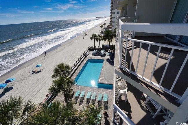 View of swimming pool with view of water and beach | Image 34