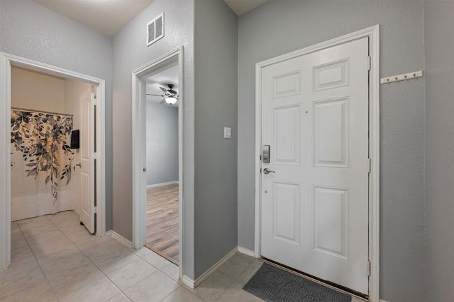 Entryway with baseboards, visible vents, ceiling fan, and light tile patterned flooring | Image 6