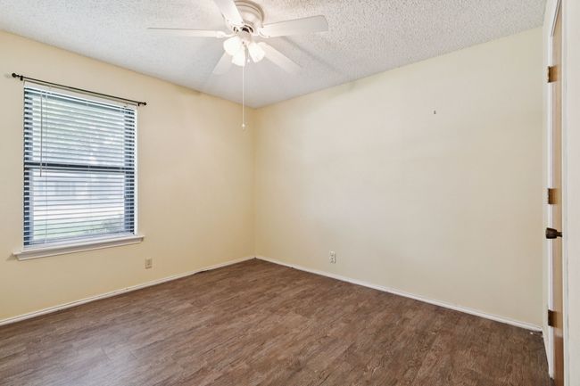 Empty room with wood finished floors, healthy amount of natural light, a textured ceiling, and ceiling fan | Image 26