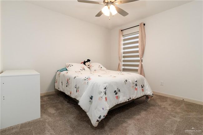 Bedroom with a ceiling fan, baseboards, and carpet flooring | Image 13