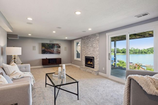 The lower level features a gas fireplace with updated marble brick surround for cozy charm and surround sound speakers for your media set up! | Image 23
