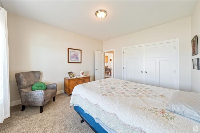 Bedroom with light colored carpet, baseboards, and a closet | Image 32