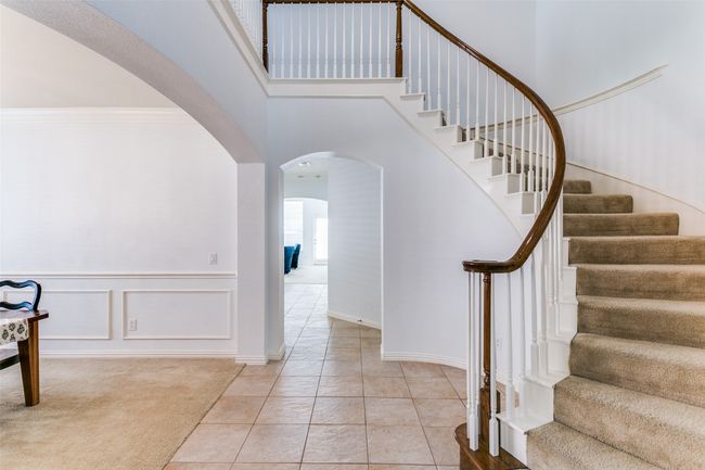 Staircase winds up the soaring ceiling to the second floor. | Image 7