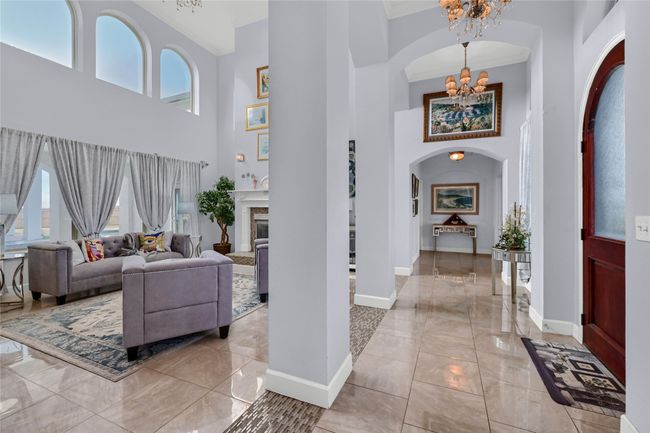 Entrance foyer with a notable chandelier, a towering ceiling, and crown molding | Image 9