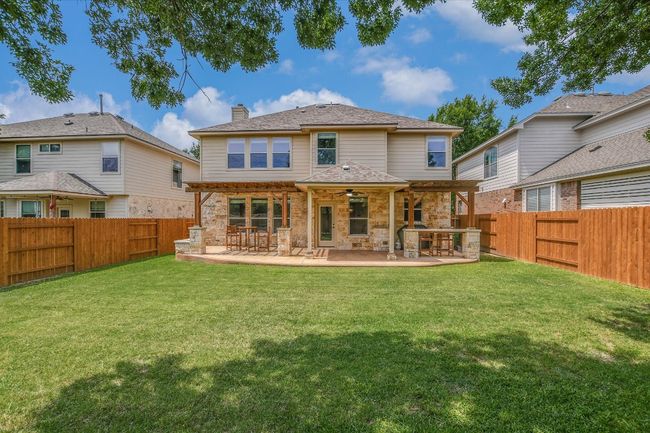 Back of property with a chimney, a patio area, ceiling fan, and stone siding | Image 27