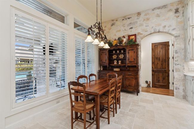 The Breakfast Areafeatures travertine flooring, a12' ceiling. A beautiful feature is the custom blend natural stoneaccent wall. | Image 13
