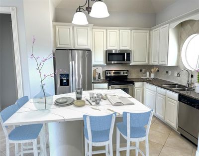 Beautiful kitchen with NEW Quartz island, granite counters, SS appliances, Freshly painted cabinets & walls. virtual staged | Image 3