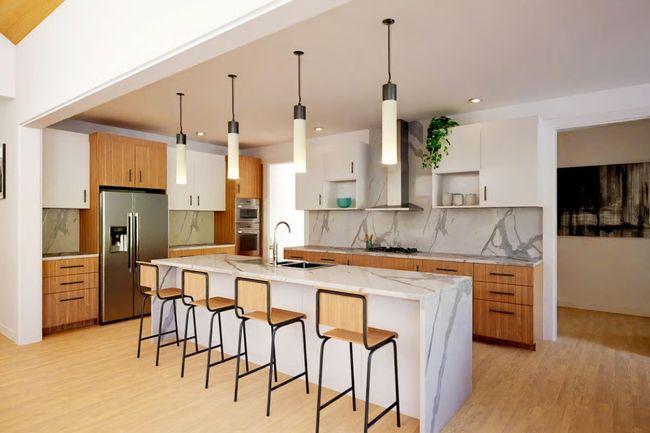 Elegant kitchen has quartz countertops with a waterfall island, custom wood cabinetry, and Thermador appliances. | Image 9