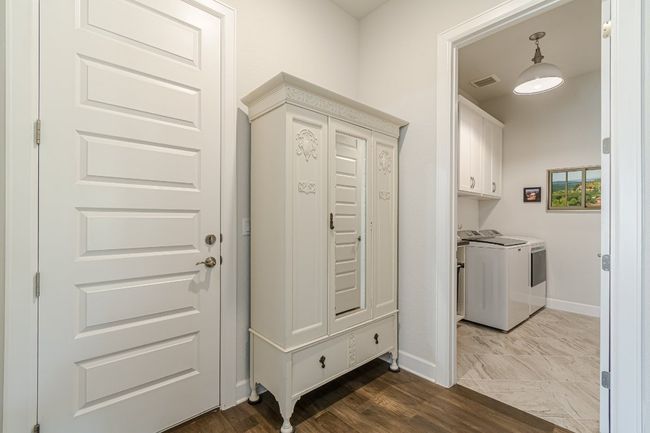 Washroom featuring washer and clothes dryer, baseboards, and cabinet space | Image 8