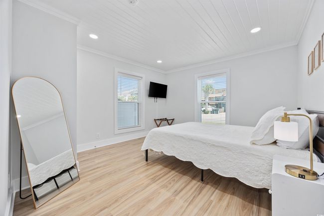 Bedroom with multiple windows, wood finished floors, crown molding, recessed lighting, and baseboards | Image 13
