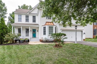 View of front facade featuring a garage, a front yard, and covered porch | Image 1