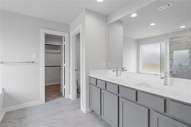 This large primary bath is spacious enough to share! With separate vanities, large closet space, plentiful cabinet and counter space, you are sure to have private area while sharing this bathroom! | Image 9