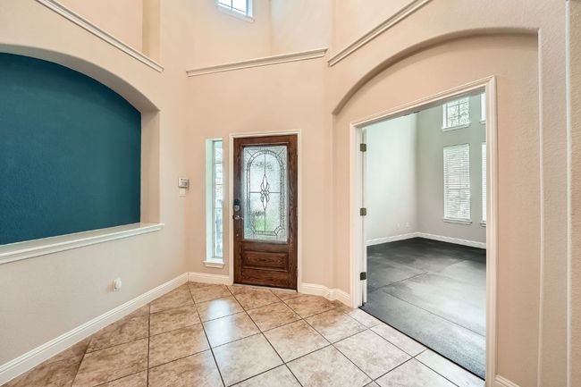 Foyer featuring baseboards, a towering ceiling, and tile patterned floors | Image 5