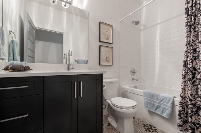 Full bathroom with toilet, shower / bath combo with shower curtain, and vanity | Image 23