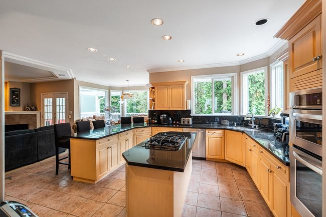 Kitchen featuring a peninsula, tasteful backsplash, appliances with stainless steel finishes, a sink, and a wealth of natural light | Image 14