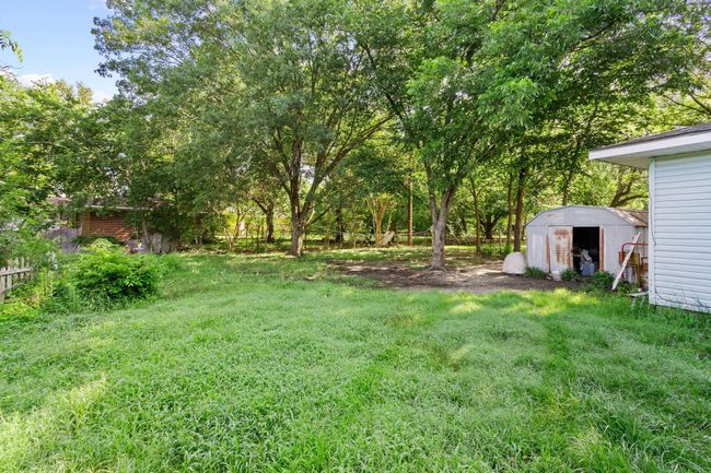 View of green lawn featuring a storage shed | Image 13
