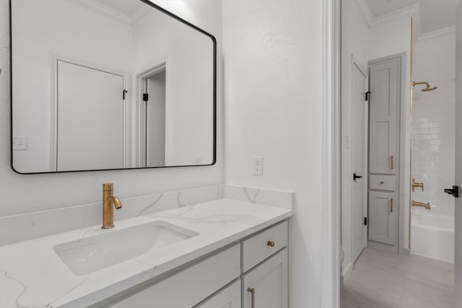 Full bath featuring crown molding, vanity, and shower / washtub combination | Image 28