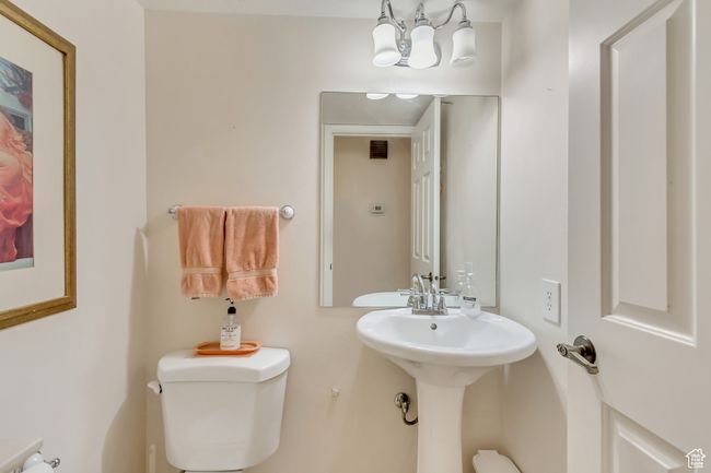 Half bathroom with toilet and a notable chandelier | Image 17