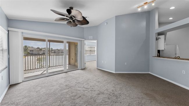 Unfurnished living room with carpet, a ceiling fan, recessed lighting, lofted ceiling, and baseboards | Image 7