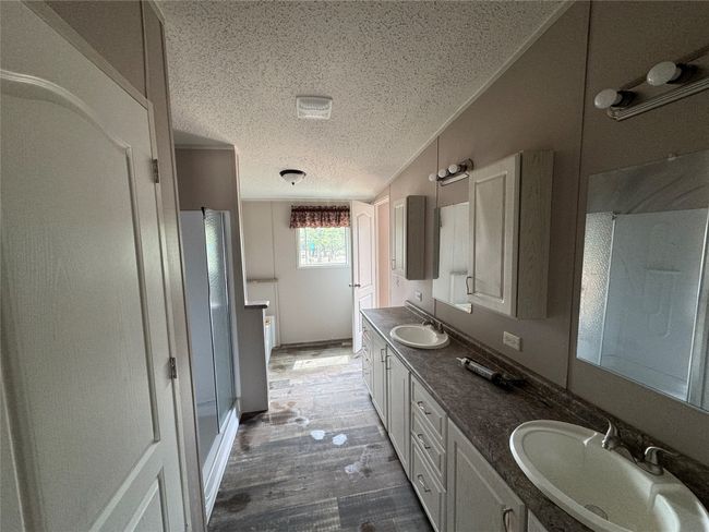 Full bath with wood finished floors, a sink, a textured ceiling, and double vanity | Image 7
