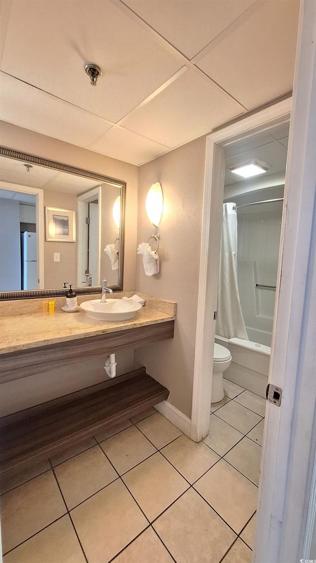 Bathroom featuring tile patterned floors, shower / bath combo, and vanity | Image 9