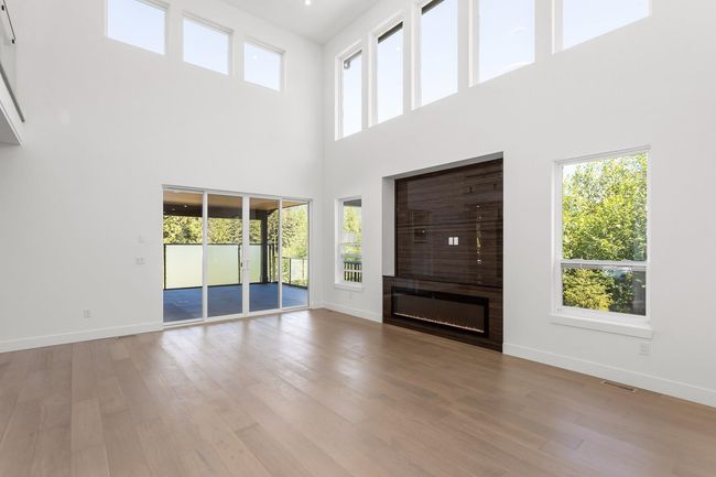 Unfurnished living room featuring a wealth of natural light, visible vents, and wood finished floors | Image 19
