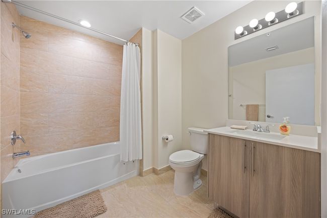 Bathroom with shower / bath combo, visible vents, toilet, and vanity | Image 10