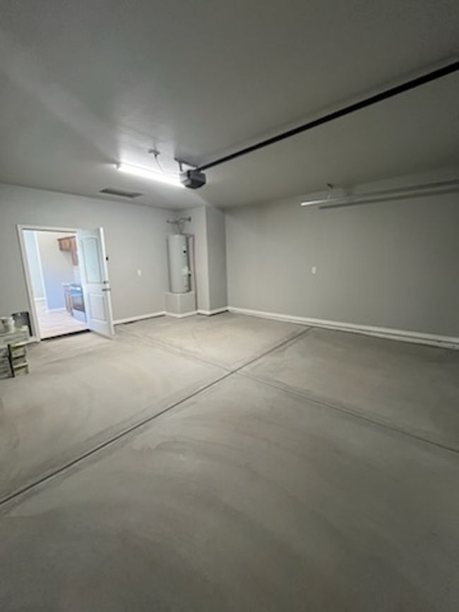 Garage with water heater and baseboards | Image 8