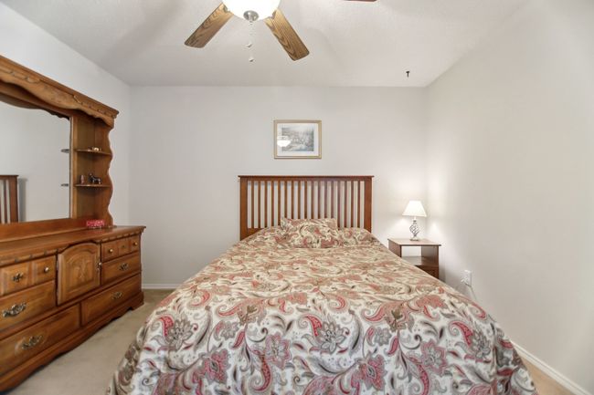 Bedroom with light colored carpet, ceiling fan, and baseboards | Image 25